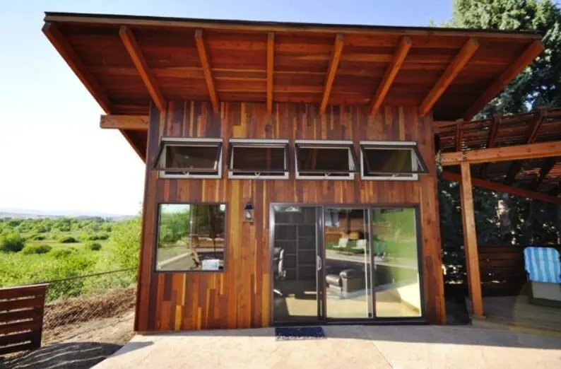 A wooden cabin with glass doors and windows
